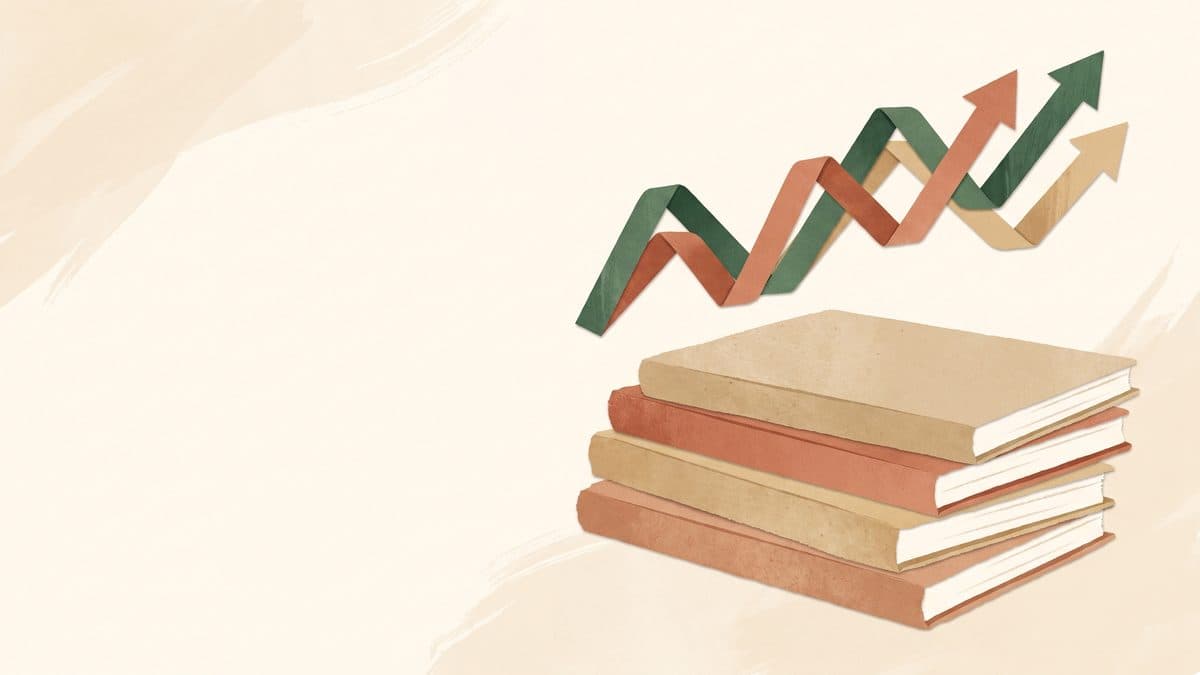 Paper-cut illustration of a stack of journals with a rising line chart made of paper strips above them